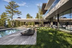 a modern house with a pool in the yard and large glass windows on the side