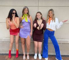 three women in dresses posing for the camera with their hands on their hipss and one holding her hand out