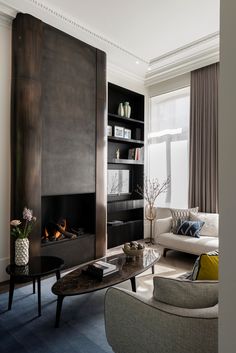 a living room filled with furniture and a fire place in the middle of the room