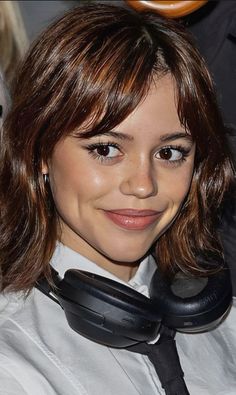 a woman wearing headphones and smiling at the camera