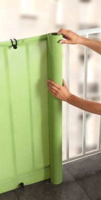 a woman is opening the green door with her hand and holding it up to the side