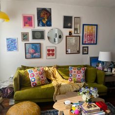 a living room filled with furniture and lots of pictures on the wall above it's coffee table