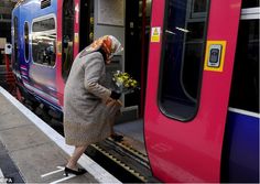 a woman is getting on the train at the station