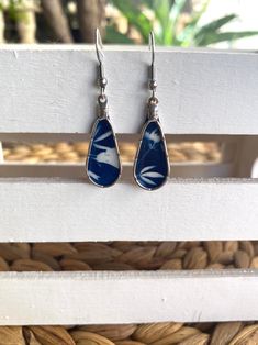 a pair of earrings with blue and white designs on them