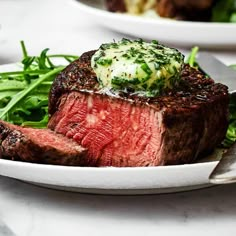 steak and greens on a white plate with silverware