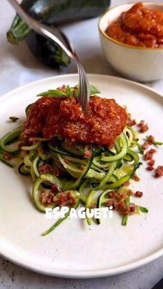 a white plate topped with zucchini and sauce