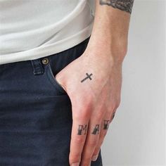 a man with a cross tattoo on his left hand and the word i am in black ink