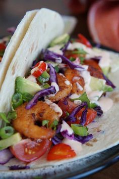 two fish tacos on a tortilla with cole slaw and avocado