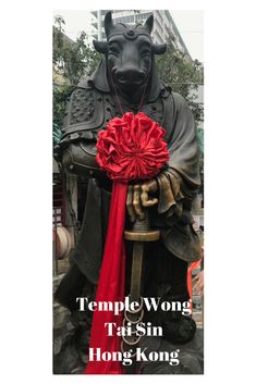 a statue with a red ribbon around it's neck and the words temple wong tai sin hong