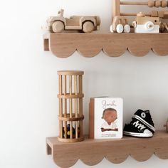 two wooden shelves with toys on top of them and a book in front of the shelf