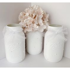 three white mason jars with flowers in them