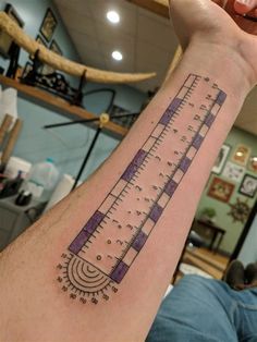 a person with a tattoo on their arm that has a large ruler tattooed on it