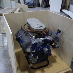 a small engine in a wooden box on the floor