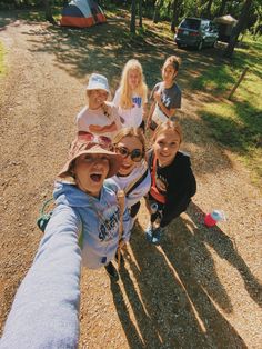 a group of kids standing next to each other on a dirt road