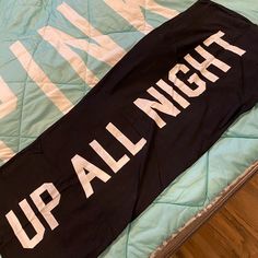 an up all night sign laying on top of a bed