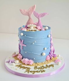 a blue cake with pink and white decorations on it's sides, under the sea