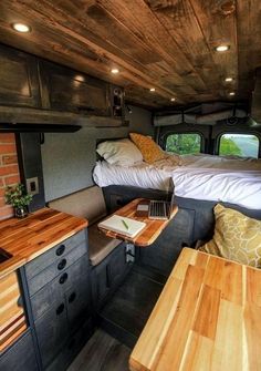 the inside of a camper with two beds and desks in it's center