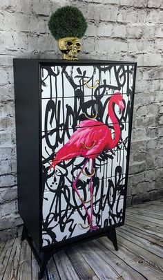 a black and white cabinet with a pink flamingo painted on it