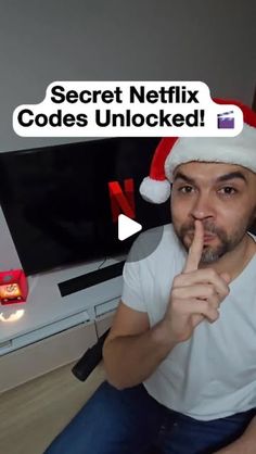 a man wearing a santa hat sitting in front of a tv with the caption secret netflix code unlocked