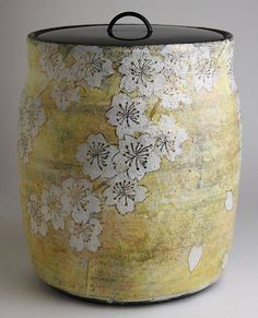 a yellow vase with white flowers on it