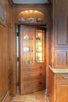 a kitchen with wooden cabinets and marble counter tops, along with an arched doorway that leads to another room