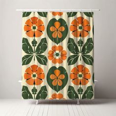 an orange and green flower shower curtain hanging on a white bathroom wall next to a wooden floor