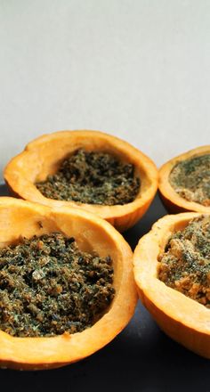 four orange halves filled with pesto and seasoning sitting on top of a table