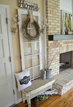 a living room with a brick fireplace and wreath on the mantle