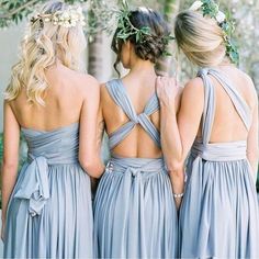 three bridesmaids in long gray dresses with flowers on their head and one wearing a flower crown