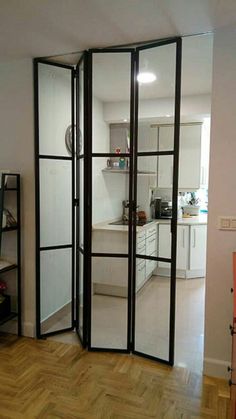 a room divider in the middle of a living room with wood flooring and white walls