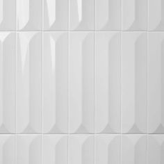 a white tiled wall with vertical lines on it