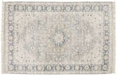 an antique rug with fringes on the edges and a medallion design in grey tones