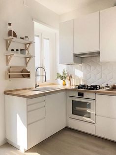 a kitchen with white cabinets and wooden floors