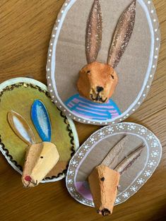 three paper plates with rabbits on them sitting on top of a wooden table next to each other