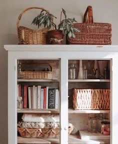 a book shelf with baskets and books on top