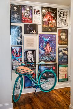 a blue bicycle parked in front of a wall with posters on it