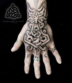 a person's hand with an intricate tattoo design on the middle of their palm