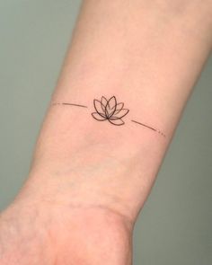 a small lotus tattoo on the wrist