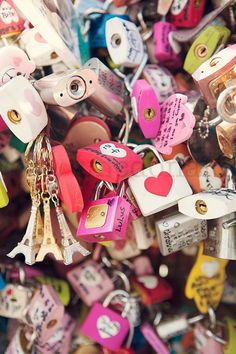 many different colored padlocks are attached to each other with hearts and keys on them