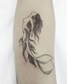 a woman's leg with a tattoo on it and an image of a mermaid