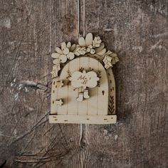 a carved wooden door with flowers and leaves on the front is hanging on a wall