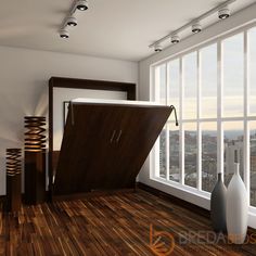 an empty room with wooden floors and large windows looking out onto the city below it