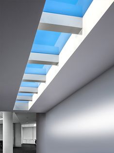 an empty room with blue skylights and white walls