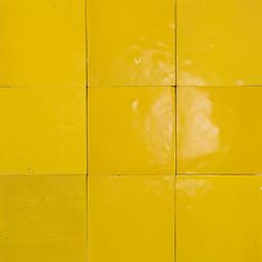 a yellow tiled wall with white tiles on it