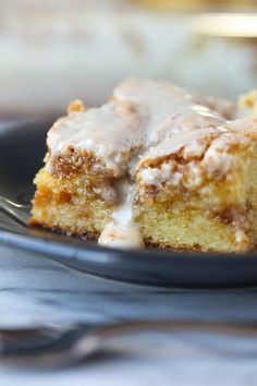 a piece of cake on a plate with a fork in it and icing drizzled over the top