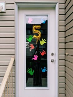 the door is decorated with handprints and balloons for someone's 5th birthday