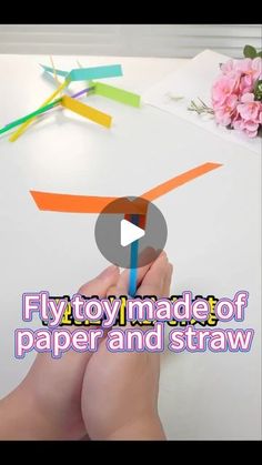 someone is making a paper and straw craft