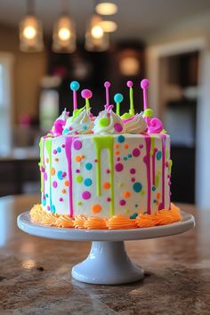 a decorated birthday cake sitting on top of a white plate with colorful icing and sprinkles