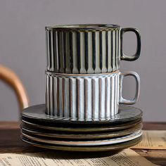 stack of stacked metal cups sitting on top of each other next to an open book