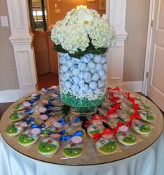 a vase filled with white flowers sitting on top of a table covered in candies